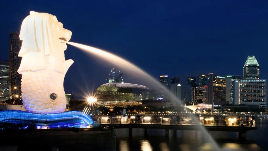 Merlion statue fountain at Marina Bay with Singapore skyline and Marina Bay Sands illuminated at night
