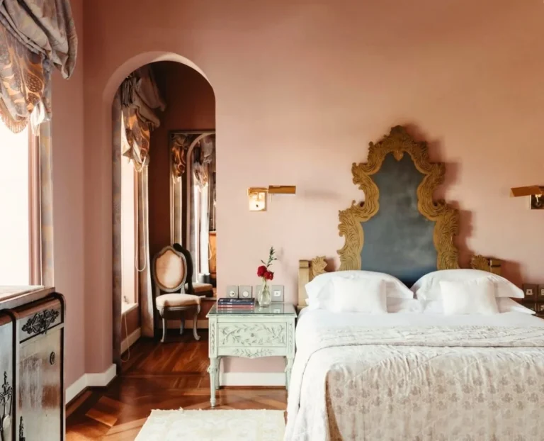 Elegant boutique hotel bedroom with vintage furniture, warm pastel tones and classic European interior design for luxury travel stays.