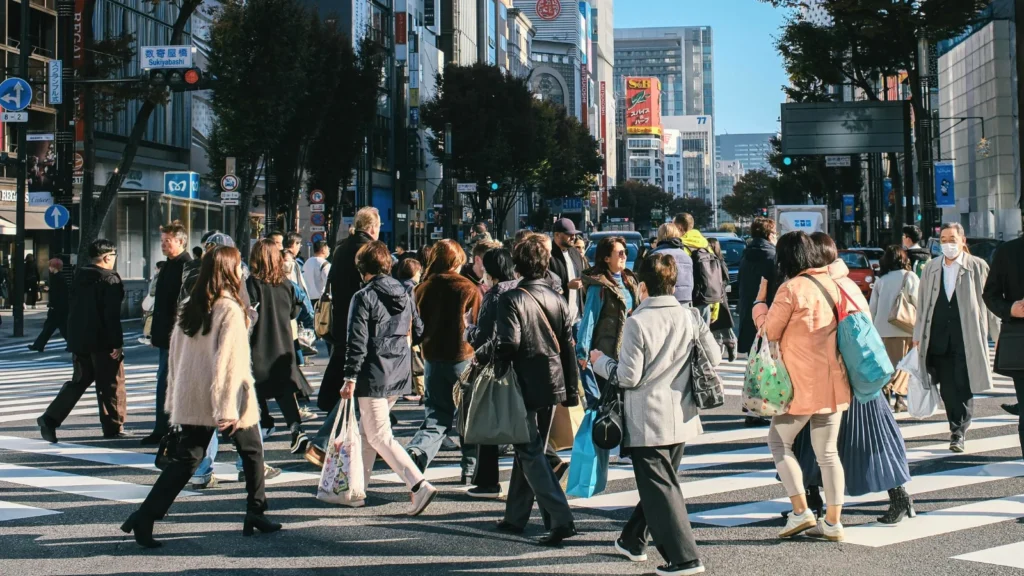 Busy pedestrian crossing in Tokyo Japan with locals and travelers walking through modern city streets