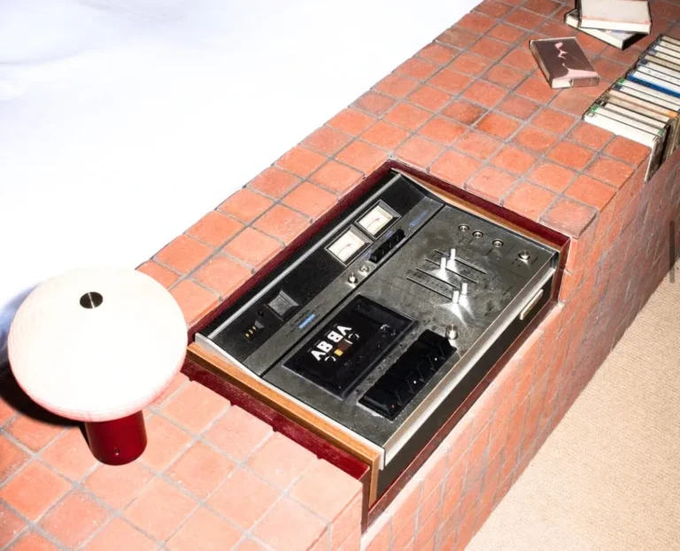 Retro listening lounge with vintage sound system and brick console table, stylish boutique hotel interior design detail.
